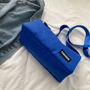 Sac bandoulière minimaliste en nylon bleu Klein avec étiquette de mode et sangle