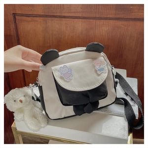 Detail of cartoon panda crossbody bag featuring plush bear charm and rabbit ear decor