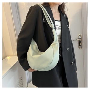 Détail du sac hobo demi-lune vert menthe en tissu texturé avec large bandoulière