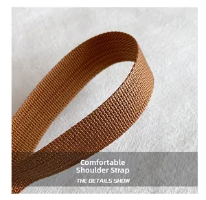Close-up of the textured brown woven shoulder strap with reinforced edges and durable fabric