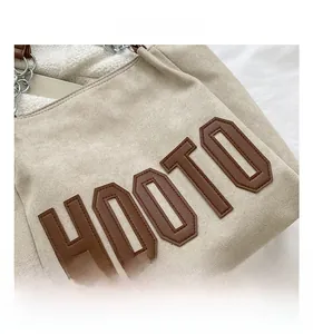 Détail du sac cabas HOOTO avec lettrage en cuir marron et doublure en fausse fourrure