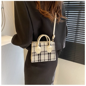 Detail der karierten Tweed-Handtasche mit cremefarbenen Ledergriffen und Gurt