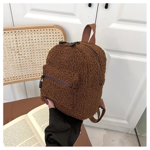 Close-up of brown faux shearling mini backpack with fluffy texture and zip details