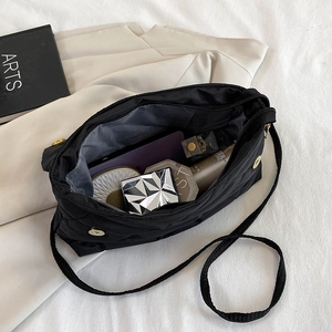 Quilted black crossbody bag with chain strap showing spacious interior for essentials