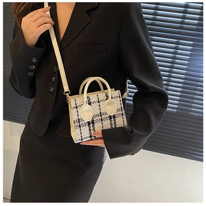 Detail einer Mini-Umhängetasche aus Tweed mit schwarz-weißem Karo und goldener Hardware