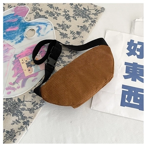 Detail of caramel corduroy crescent bag with textured stripes and black adjustable strap