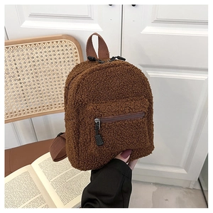 Detail of dark brown faux shearling texture on a mini teddy fleece backpack with front zipper