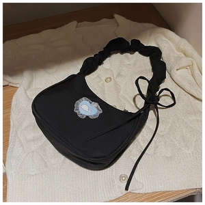 Detail der schwarzen gefalteten Schultertasche mit Wal-Herz-Patch und Spitzenbandschlaufen