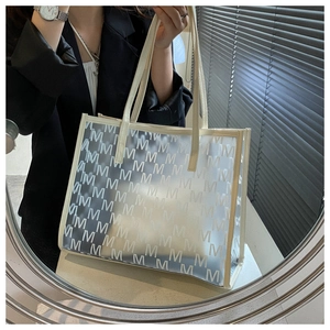 Close-up of beige tote bag featuring frosted texture and monogram M pattern