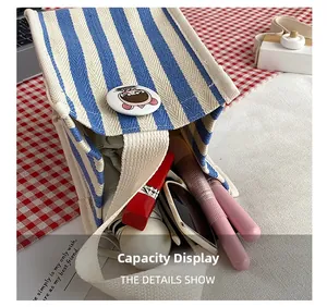Detail view showing internal storage capacity of blue striped canvas handbag with makeup