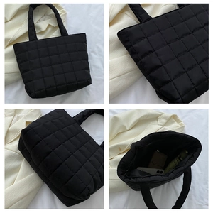 Detail view of black quilted tote bag showing spacious interior and soft padded handles