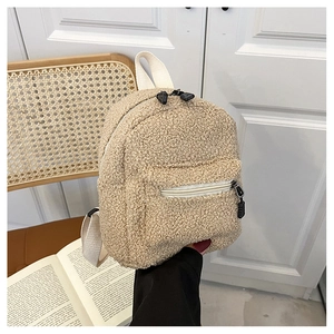 Mini beige faux shearling backpack held by hand featuring soft teddy fleece texture