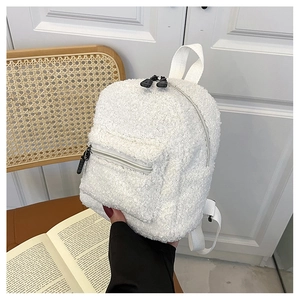 Detail shot of white fuzzy mini backpack featuring soft faux fur and dual zipper pockets