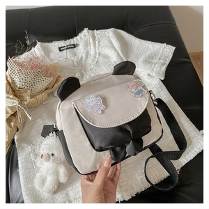 Close-up of panda crossbody bag with cute patches and a plush bear pendant charm