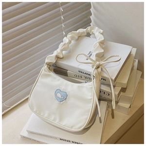 Detail der cremefarbenen Tasche mit blauem Wal-Herz-Spitzenbesatz und gerafftem Griff