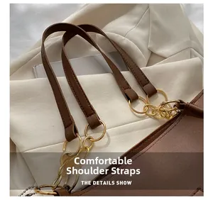 Detail of comfortable brown leather shoulder strap with gold chain links and rings