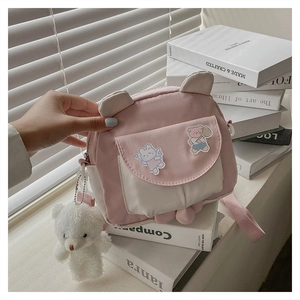 Close-up of pink rabbit ear crossbody bag featuring cute cartoon bear and rabbit patches