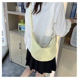 Gros plan d'un sac à bandoulière en forme de croissant jaune clair en toile durable