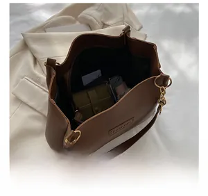 Brown vintage tote bag interior showing large capacity with pockets and bear charm