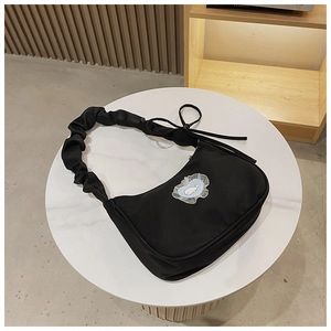 Details der schwarzen Schultertasche mit Wal-Stickerei und gerafftem Riemen