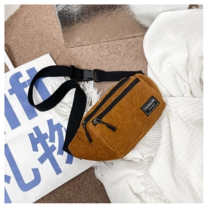 Close-up of brown corduroy waist bag showing double zippers and brand label detail