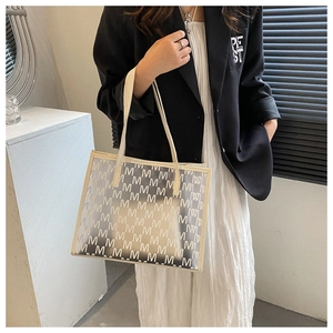 Detail of trendy PU tote bag with geometric M patterns worn by model in minimalist setting