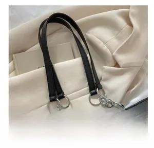 Gros plan d'un sac cabas en cuir noir avec chaînes argentées et détails plissés