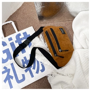 Close-up of brown corduroy chest bag with zipper pockets and a fashion label