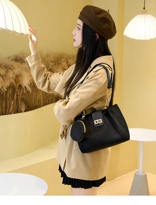 Detail of black velvet tote bag with gold buckle, chain strap and small round coin purse