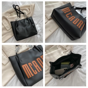 Vues détaillées d'un sac cabas en similicuir noir avec lettrage orange et chaîne