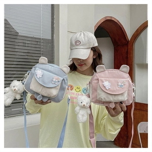 Detail of cartoon bunny canvas crossbody bag with teddy bear charm and cute patches