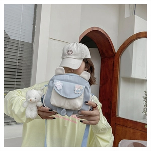 Close-up of cute cartoon rabbit ears bag with soft plush bear charm and canvas details