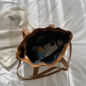 Large brown soft leather tote bag with spacious interior and multi-function pockets
