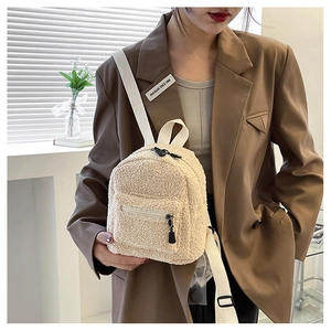 Close-up of fluffy off-white faux shearling mini backpack with adjustable woven straps