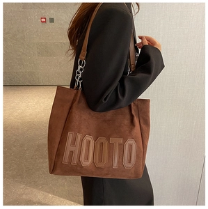 Détail du sac cabas en daim marron foncé avec lettrage HOOTO et bandoulière à anneau