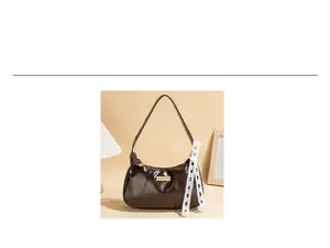 Detail of a brown PU leather underarm bag featuring a lace ribbon and metal nameplate