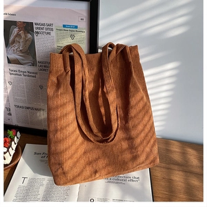 Dettaglio di una borsa tote in velluto a coste marrone con trama a coste visibile