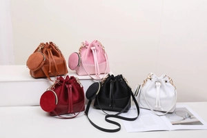Detail view of colorful drawstring bucket bags in smooth leather and soft suede texture