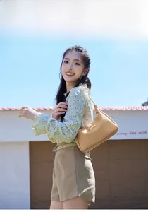 Gros plan détaillé du sac à bandoulière beige à texture tissée avec fine lanière