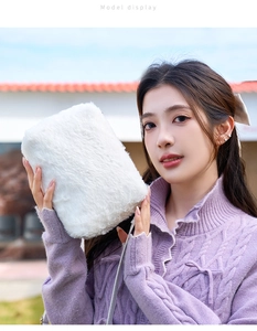 Détail d'un sac en peluche blanche douce avec bandoulière fine sur un pull couleur lavande