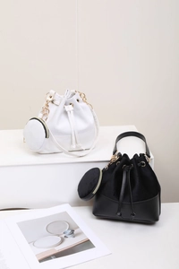 Detail of drawstring bucket bag set in black and white with gold chain coin purse