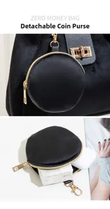 Close-up of detachable black round coin purse with gold zipper and spring hook detail