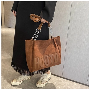 Détail du sac cabas en daim marron avec lettres HOOTO en relief et chaîne en métal