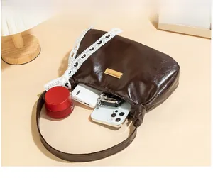 Deep brown PU leather shoulder bag interior showing storage for phone and cosmetics