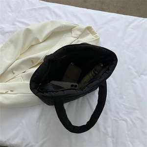 Large black quilted tote bag with diamond stitching and spacious interior compartment