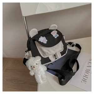 Detail of cute bear ear crossbody bag with plush charm and contrast stitching