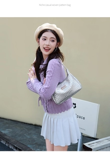 Détail du sac hobo tissé argenté avec texture métallique et plaque de logo rectangulaire