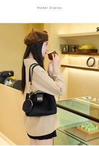 Detail of black suede tote bag featuring a gold twist lock and a round coin purse charm