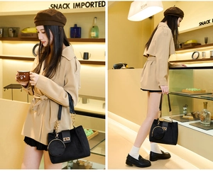 Detail of black velvet tote bag with golden lock and chain on stylish trench coat