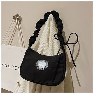 Detail einer schwarzen Canvas-Tasche mit blauem Karo-Herz und Spitzenbesatz am Walmuster